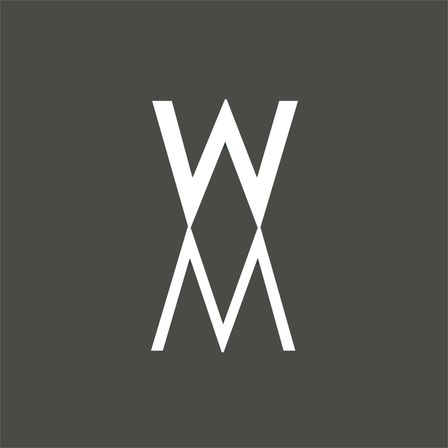 Ein weißes Monogramm mit einem großen W und einem M, die übereinander gestapelt sind, auf einem grauen Hintergrund dargestellt.