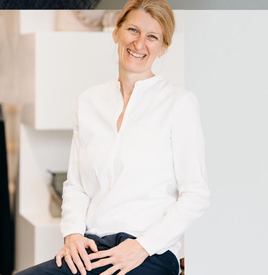 Bild enthält, Face, Head, Person, Smile, Blouse, Adult, Female, Woman, Long Sleeve, Coat