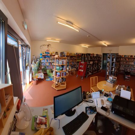 Bild enthält, Furniture, Table, Desk, Screen, Book, Computer Hardware, Monitor, Library, Building, Laptop