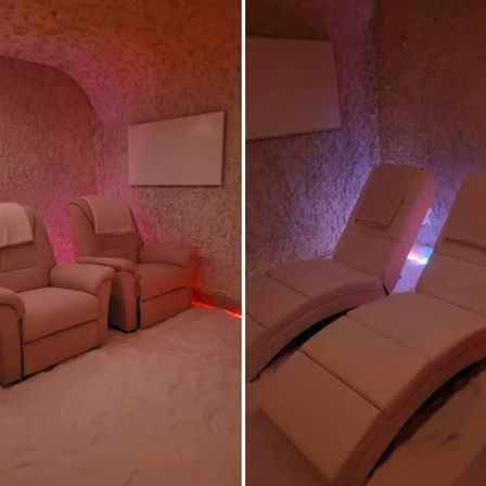 Ein gemütlicher Innenbereich zur Entspannung mit zwei Liegestühlen, einer mit einem Handtuch darauf, beleuchtet von rosa Lichtern.