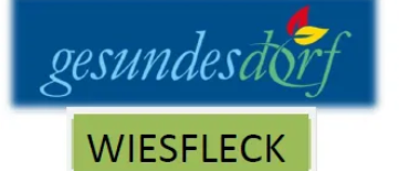 Das Logo für 'Gesundes Dorf' ist auf blauem Hintergrund mit einem roten und grünen Blatt abgebildet, darunter steht 'Wiesfleck' in weiß.