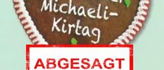 Ein herzförmiges Lebkuchen mit 'Ubelbacher Michaeli-Kirtaq' darauf geschrieben. Darunter steht ein roter Aufkleber mit der Aufschrift 'ABGESAGT'. Der Lebkuchen hat weiße Zuckergussdetails.