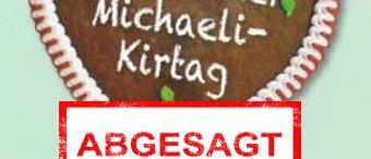 Ein herzförmiges Lebkuchen mit 'Ubelbacher Michaeli-Kirtaq' darauf geschrieben. Darunter steht ein roter Aufkleber mit der Aufschrift 'ABGESAGT'. Der Lebkuchen hat weiße Zuckergussdetails.