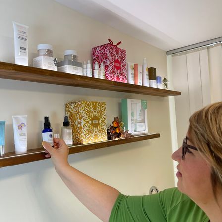 Bild enthält, Shelf, Adult, Female, Person, Woman, Cabinet, Furniture, Perfume, Face, Glasses