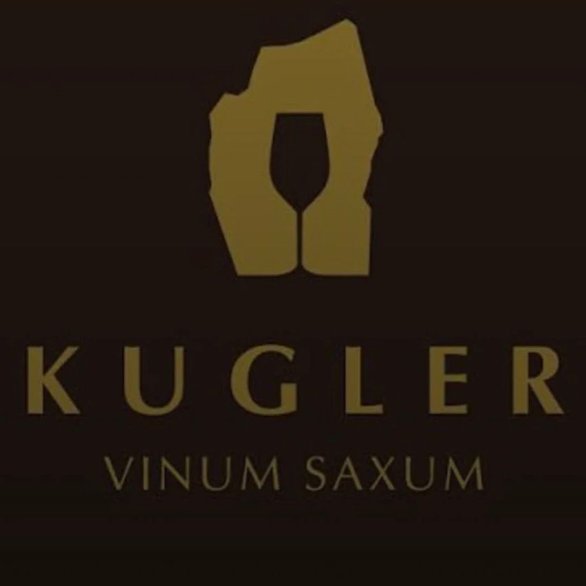 Das Logo von Kugler Vinum Saxum zeigt ein goldenes Design mit einem Weinglas und einem Felsen. Der Text Kugler Vinum Saxum ist in goldenen, fetten Buchstaben geschrieben.