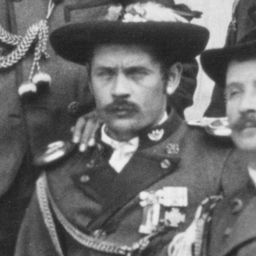 Ein Schwarz-Weiß-Foto von zwei Militäroffizieren. Ein Offizier trägt einen Hut und Medaillen. Der andere Offizier hat seine Hand auf der Schulter des Mannes vor ihm.