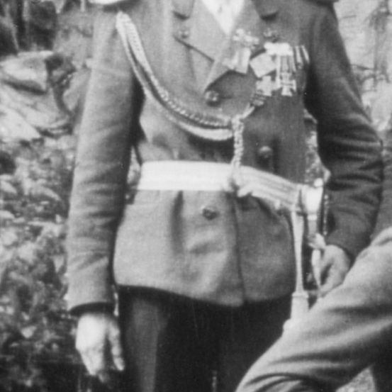 Ein altes Schwarz-Weiß-Foto eines Mannes in Uniform im Freien.