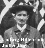 Ein Schwarz-Weiß-Foto eines Mannes in Uniform, der einen Hut trägt. Sein Name ist Ludwig Hillebrand, und er wird als Jodler Luck identifiziert.