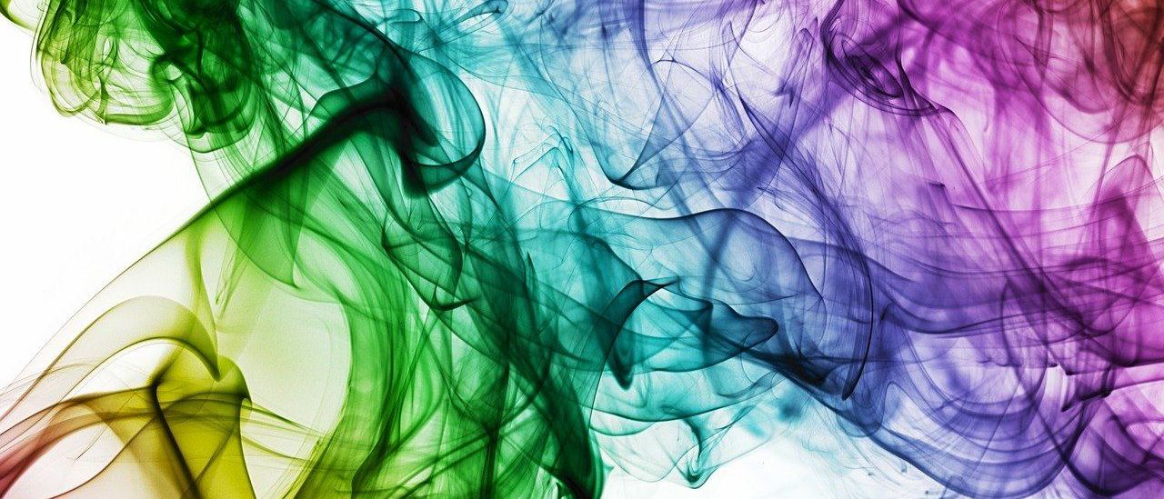 Ein lebendiges, mehrfarbiges abstraktes Bild von Rauch oder Dampf, mit Grün-, Blau-, Lila- und Gelbtönen, die sich vermischen und gegen einen weißen Hintergrund schwappen.