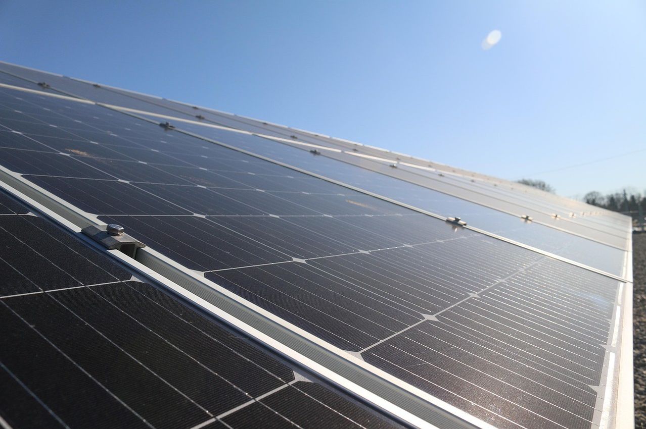 Close-up view of multiple solar panels installed on a rooftop against a clear blue sky.