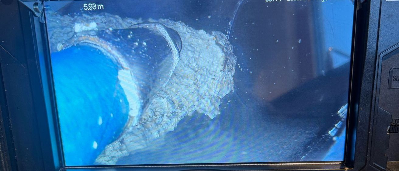Eine auf einem Rohrinspektionsgerät montierte Kamera zeigt ein Unterwasserbild. Der Bildschirm zeigt 5,93 Meter und Datum und Uhrzeit sind 08:14 am 11. April 2025. Die Tasten sind mit Meter Null, Menü, %, OK Home, REC und Power beschriftet.