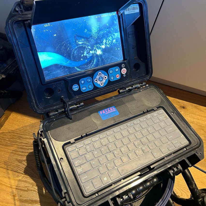 Ein offenes Unterwasser-Inspektionsgerät mit einem Monitor, der eine Wasserströmung anzeigt. Es hat eine Tastatur, Tasten und einen Aufkleber mit Text auf dem Bildschirm.