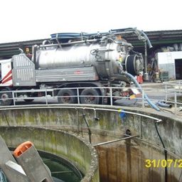 Ein großer weißer Lkw mit einem silbernen Tank steht neben einem Betontank. Der Lkw hat einen großen Schlauch, der mit dem Tank verbunden ist. Ein Datumsstempel vom 31/07/2014 befindet sich auf dem Bild.