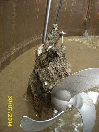 Ein untergetauchter Felsen mit einem Propeller befindet sich in einem Tank, datiert auf 30/07/2014. Der Tank ist mit trübem Wasser gefüllt.