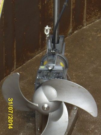 Ein Propeller aus Edelstahl ist an einem schwarzen Motor befestigt, der mit einem gelben und schwarzen Kabel versehen ist und auf einem Betonboden ruht. Das Datum 3/10/2014 ist auf der linken Seite des Bildes sichtbar.