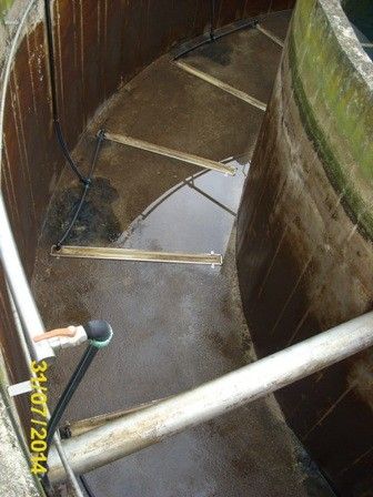 Ein Innenansicht eines zylindrischen Tanks zeigt Stufen, die nach unten führen. Wasser füllt den unteren Teil, und Metallstangen sind sichtbar. Ein Wasserzeichen zeigt das Datum 3/11/2004 an.