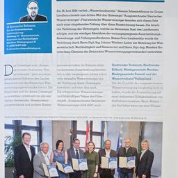 Das Bild zeigt eine Zertifikatsverleihungszeremonie mit mehreren Personen in formeller Kleidung, die Urkunden halten. Der Hintergrund ist innen und zeigt eine Flagge und ein Fenster. Eine Person in Anzug sticht in der Mitte hervor.