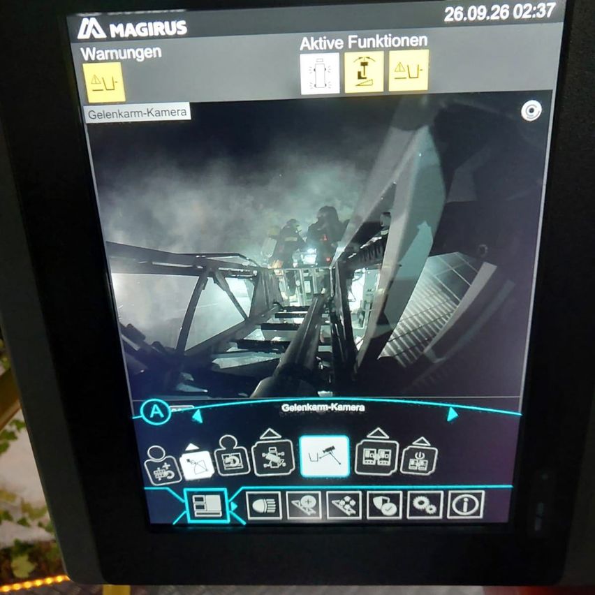 Ein Magirus-Monitor zeigt ein Live-Feed von einer Gelenkkamera mit aktiven Funktionssymbolen und einem Zeitstempel von 26.09.26 02:37.