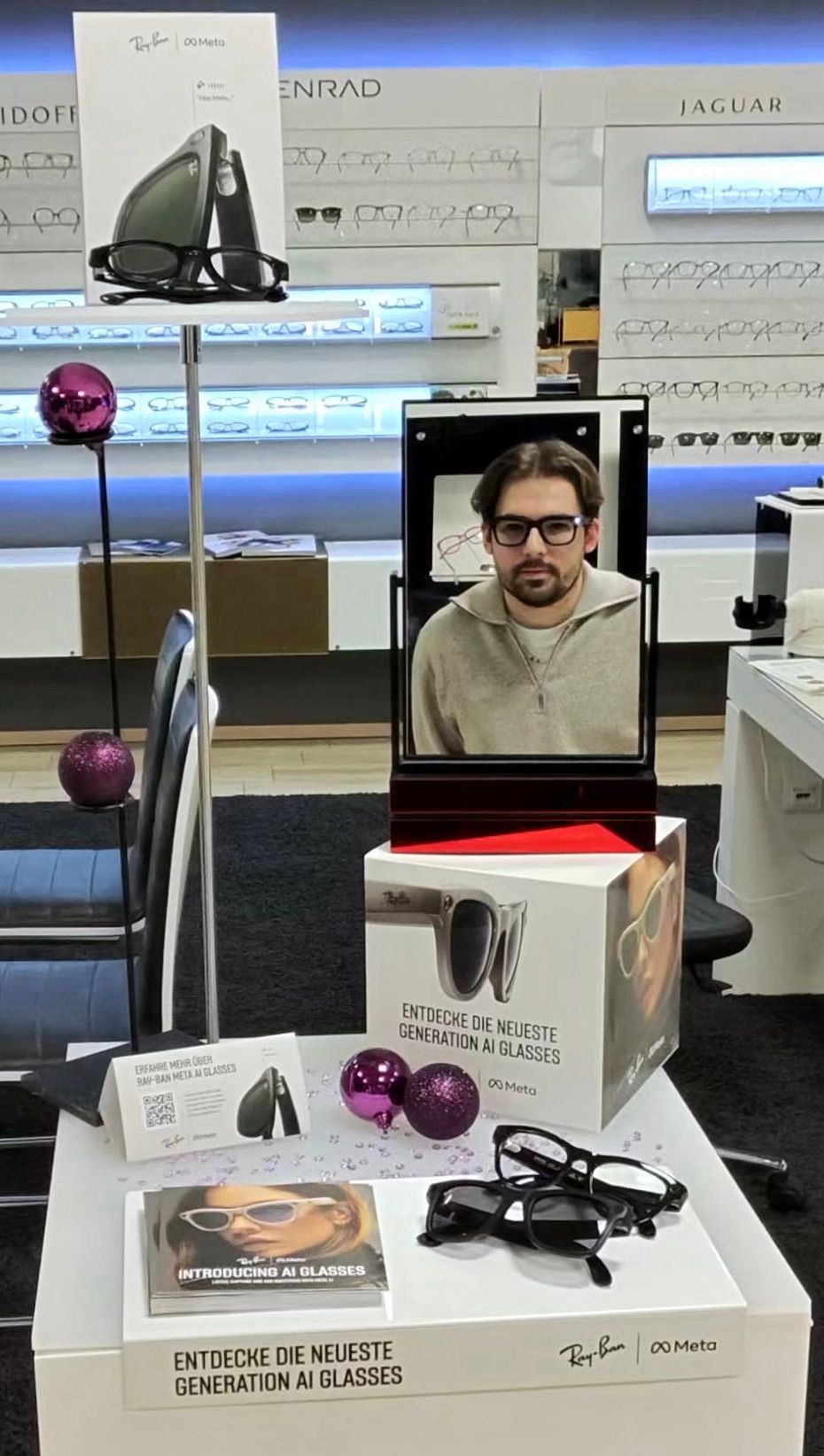 Ein Mann mit Brille wird in einem Kasten in einem Geschäft ausgestellt und präsentiert die neueste Generation von KI-Brillen.