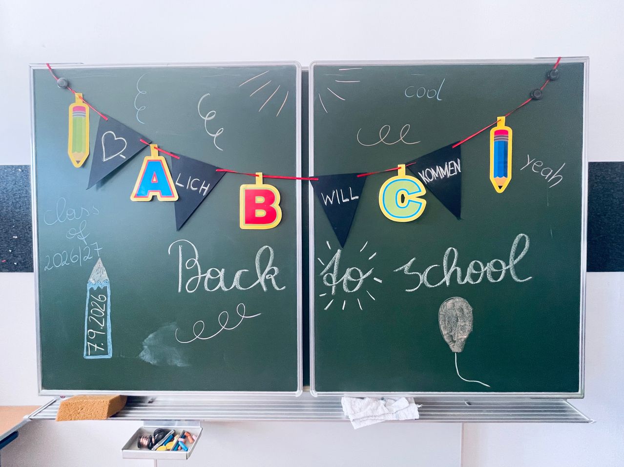 Two chalkboards with colorful decorations. One says 'Back to School' and the other has letters A, B, and C. There's a banner with a pencil and balloon.