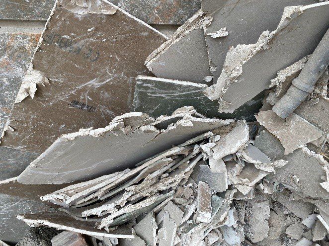 Eine Ansammlung von zerbrochenen und verwitterten Beton- und Steintrümmern. Einige Stücke zeigen sichtbare Schäden und Risse.