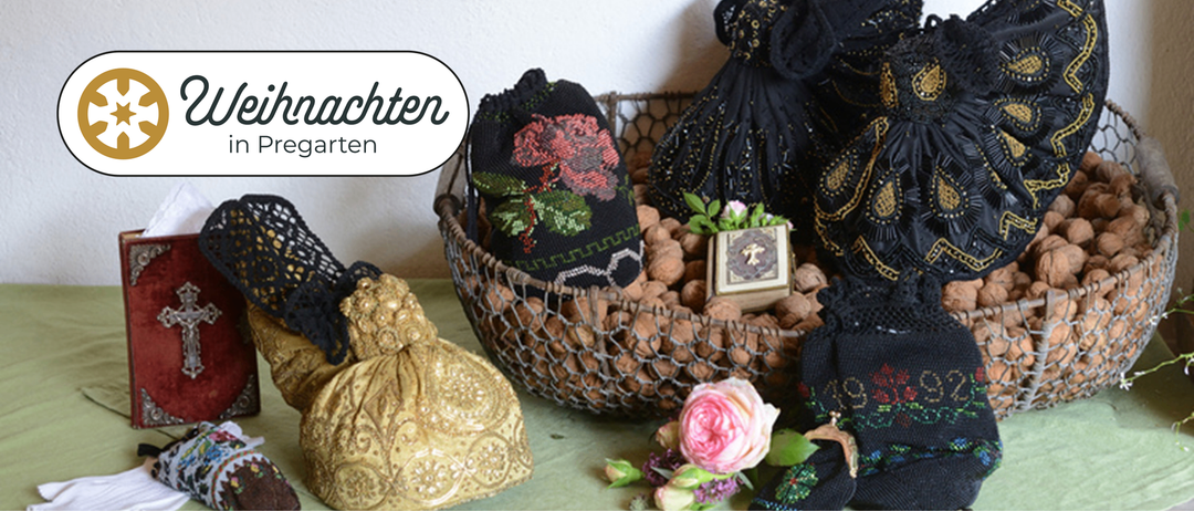 Ein Korb voller Walnüsse, geschmückt mit einem bestickten Beutel mit einer Rose, liegt neben einem kunstvollen goldenen Beutel und einer kleinen Schachtel mit aufwendigen Verzierungen.