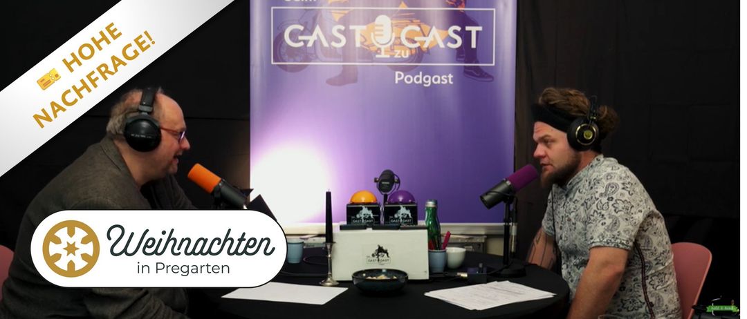 A purple backdrop with the CASTcast Podcast logo. On a table, there are microphones, a candle, a box, a bowl, and a bottle. Papers and a cup are on the table. The word "chten" is on the left side.