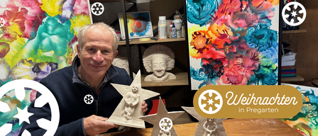 A man holding a clay star sculpture with a woman inside, set in an art studio with shelves of art supplies and a vibrant painting in the background.