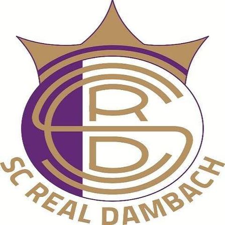 Das Logo von SC Real Dambach zeigt ein stilisiertes 'S', 'R' und 'D' mit einer Krone oben, in den Farben Lila und Gold.
