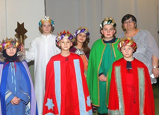 Eine Gruppe von Kindern in bunten Kostümen und Kronen posiert für ein Foto.