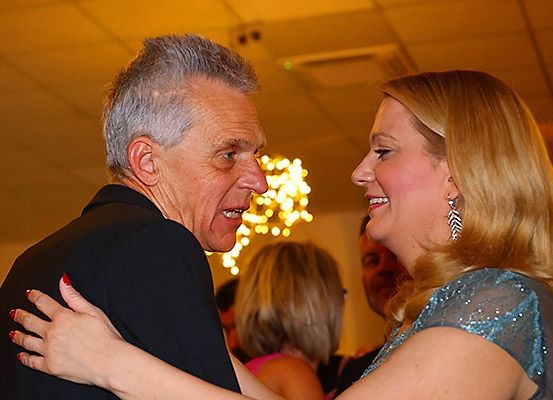 Ein Mann und eine Frau tanzen eng beieinander auf einer Party, sie lächeln und genießen den Moment.