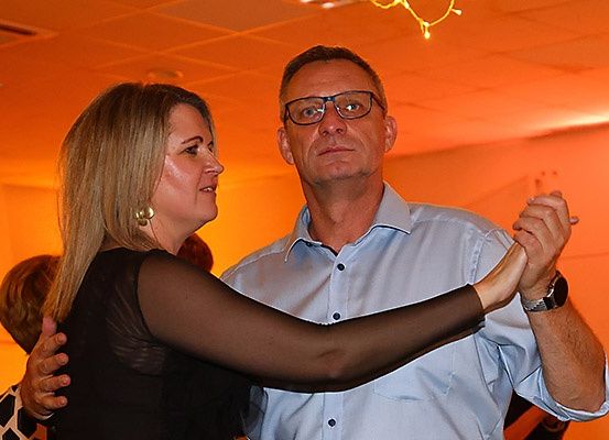 Ein Mann und eine Frau tanzen eng beieinander in einem schwach beleuchteten Raum.