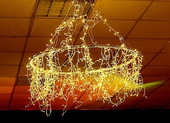 Eine goldene Kronleuchter mit mehreren Lichtern, die von der Decke hängen und eine warme und einladende Atmosphäre schaffen.