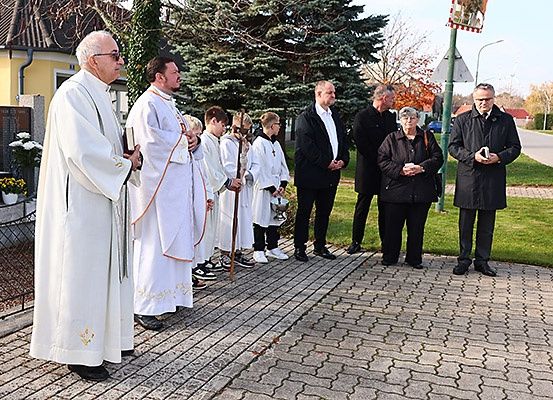 Eine Gruppe von Personen in weißen Gewändern steht in einer Reihe auf einem gepflasterten Weg, möglicherweise für eine Zeremonie.