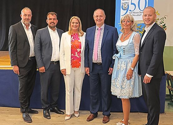 Fünf Personen stehen gemeinsam, möglicherweise bei einer Feier, vor einem blauen Hintergrund mit '150' und 'Jet Novo Sei'.