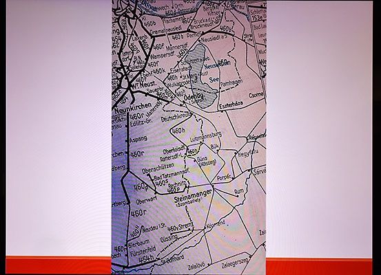 Eine Karte, die geografische Details wie Höhenangaben und Ortsnamen einer bestimmten Region zeigt. Die Karte hat einen weißen Hintergrund mit einem roten Rand am unteren Rand.