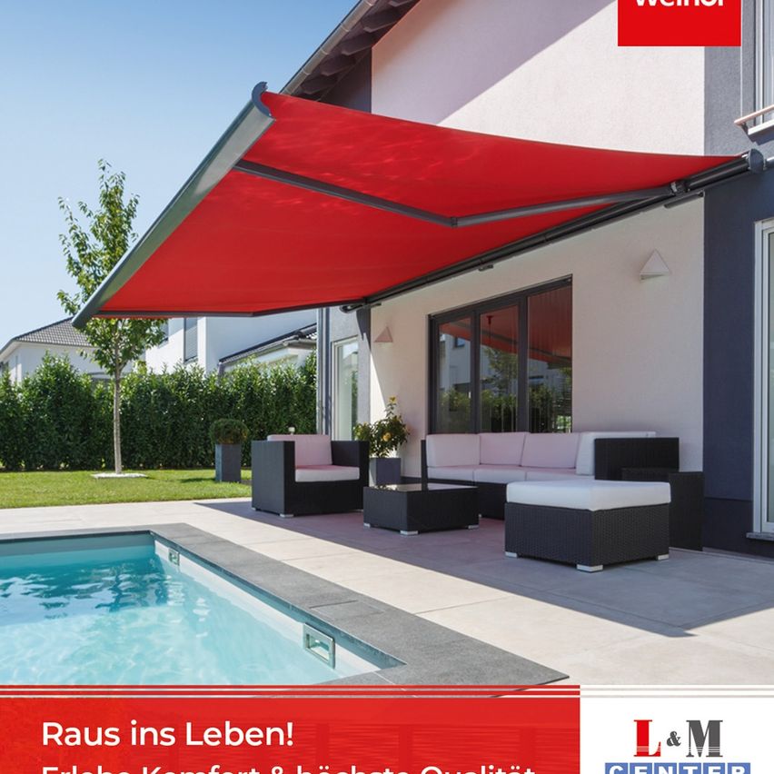 Ein rotes Sonnensegel befindet sich über einer Terrasse mit einer Couch, einem Ottoman und einem Pool. Die Terrasse grenzt an ein Haus mit einer Glastür und einem Fenster. An der Wand befindet sich eine Lampe.