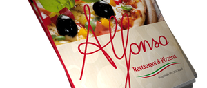 Ein Buch mit dem Titel 'Alfonso' zeigt eine Pizza mit Oliven und Basilikum. Der Buchdeckel hat einen roten Rand.