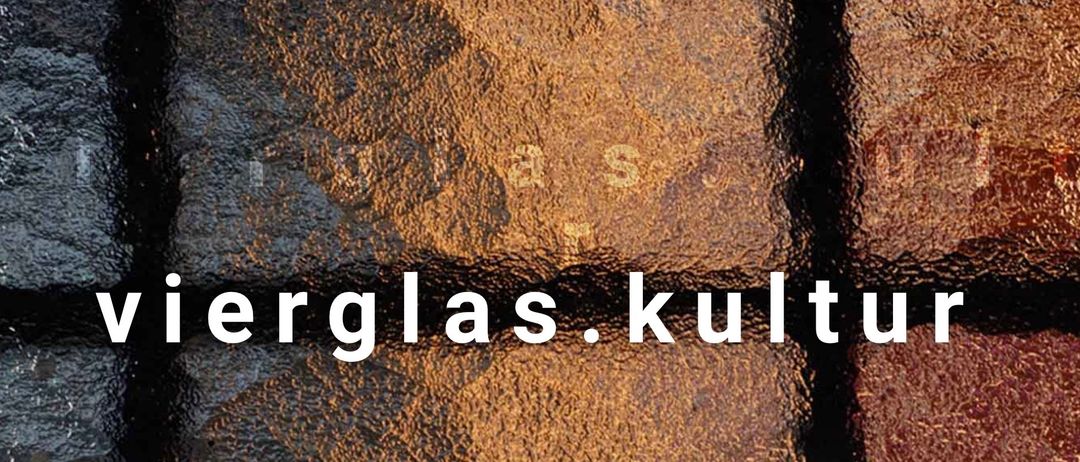 Das Wort 'Glas' ist in einer fetten weißen Schrift auf einem strukturierten braunen Hintergrund geschrieben. Es scheint Teil einer größeren Werbung oder eines Werbematerials zu sein.
