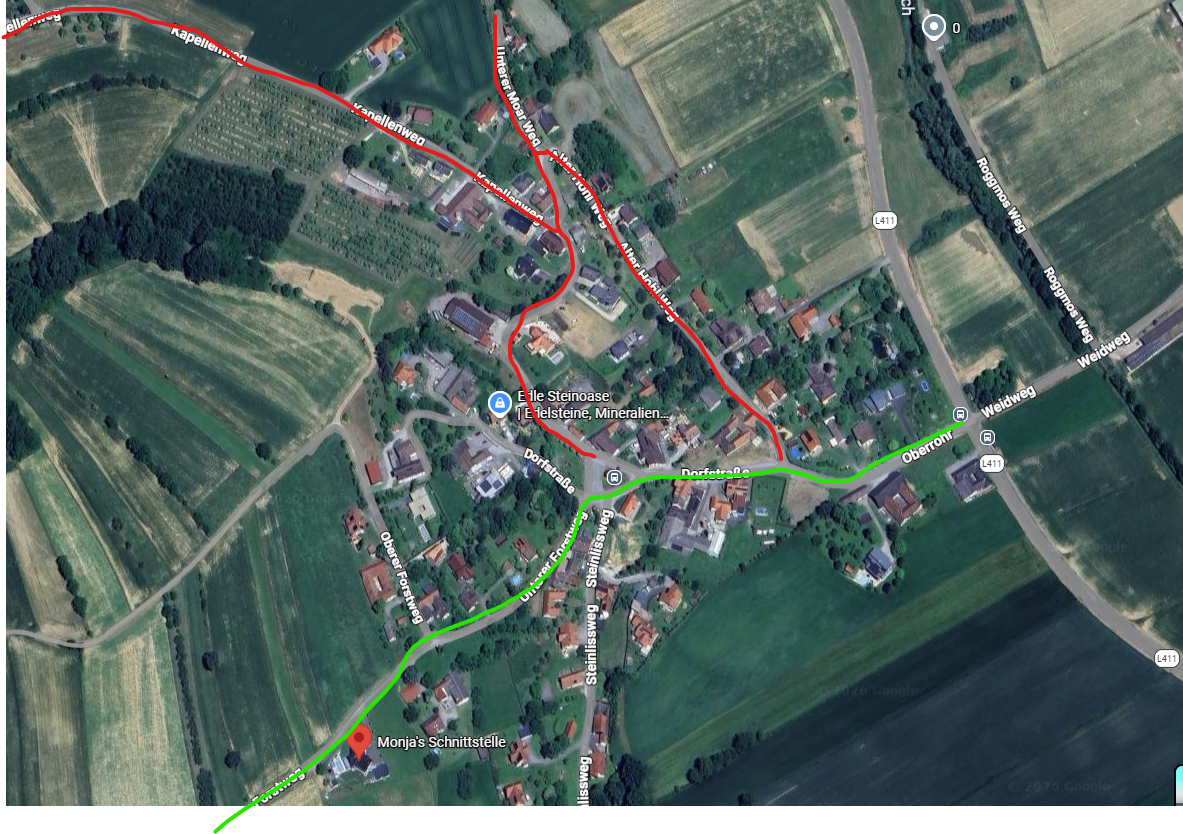 Eine Satellitenansicht eines ländlichen Gebiets mit einem markierten Wanderweg. Gebäude sind verstreut mit Straßen und Wegen. Bemerkenswerte Punkte sind Monikas Schnittstelle und Eile Steinnase.
