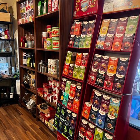 Ein Holzladen-Interieur mit Holzregalen auf beiden Seiten, gefüllt mit verschiedenen Tees und anderen Produkten.