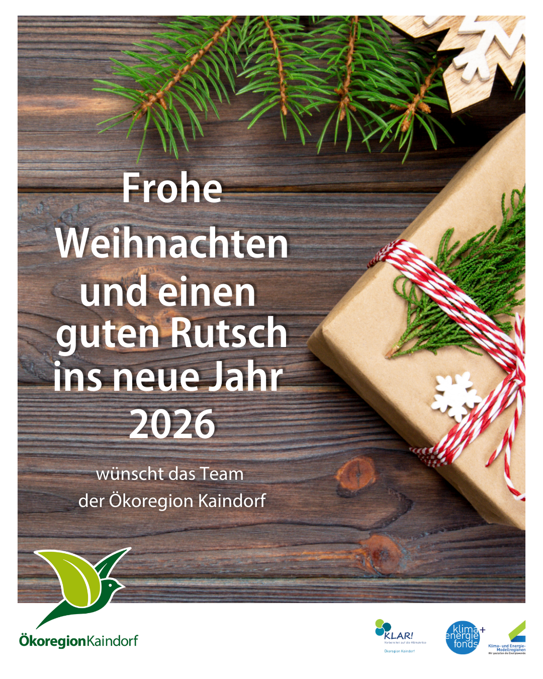 Ein Geschenk mit einem roten und weißen Band und Weihnachtsdekorationen. Der Text lautet 'Frohe Weihnachten und einen guten Rutsch ins neue Jahr 2026'. Unter dem Geschenk befindet sich ein Logo.
