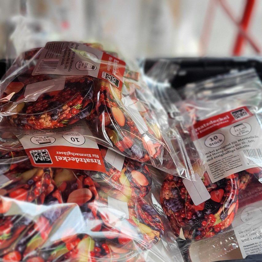 Several plastic bags contain a mix of fruits including strawberries, blueberries, and blackberries. Each bag is labeled with the product name and nutritional information. The fruit mix is likely a health snack.