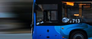 Ein blauer Bus mit der Nummer 2713 fährt auf einer Straße, der Hintergrund ist unscharf.