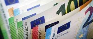 Nahaufnahme eines Stapels verschiedener Euro-Banknoten, einschließlich 10, 20 und 50 Euro Scheine, mit der Flagge der Europäischen Union und einigen Texten auf den Scheinen.