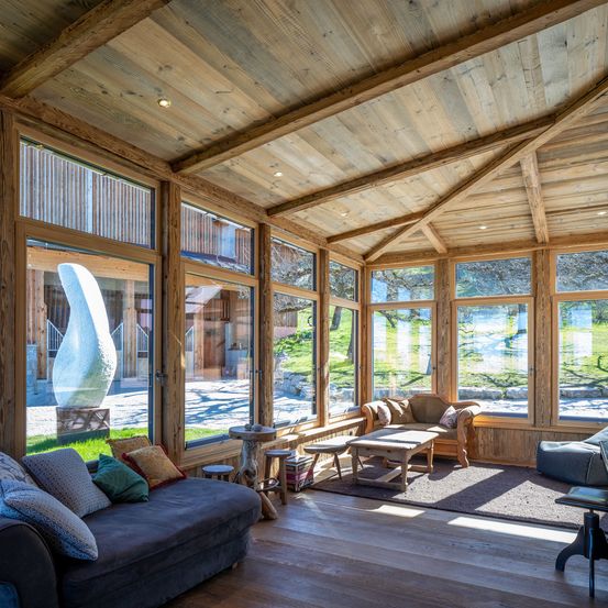 Bild enthält, Indoors, Interior Design, Wood, Hardwood, Couch, Stained Wood, Living Room, Table, Window, Chair