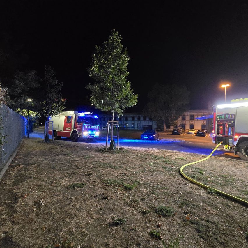 Feuerwehrfahrzeuge mit Blaulicht und Schlauch im nächtlichen Einsatz in Österreich