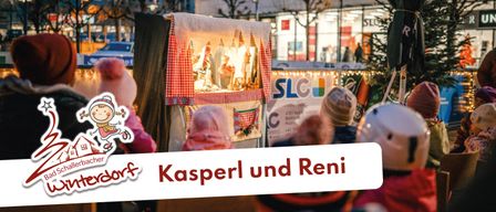 Kinder schauen sich eine Puppenshow an einem Winterabend an. Das Schild sagt 'Kasperl und Reni'. Im Hintergrund sind Bäume und ein Gebäude zu sehen.
