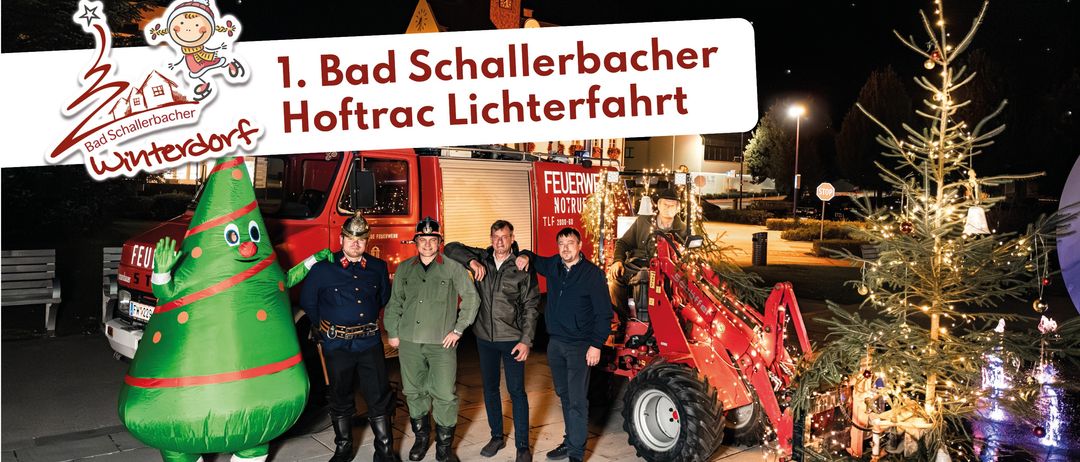 Fünf Männer posieren mit einem Feuerwehrauto und einem Traktor mit Weihnachtsbeleuchtung. Ein riesiger aufblasbarer Weihnachtsbaum steht in der Nähe.