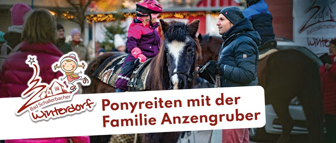Ein Kind reitet auf einem Pferd, während ein Mann die Zügel hält. Das Kind trägt einen Helm und Handschuhe. Der Mann trägt eine Mütze und eine gefütterte Jacke. Das Pferd hat einen weißen Fleck auf dem Gesicht. Im Hintergrund befindet sich ein roter Stall.